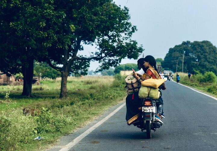 A man and a woman on a bike in rural India